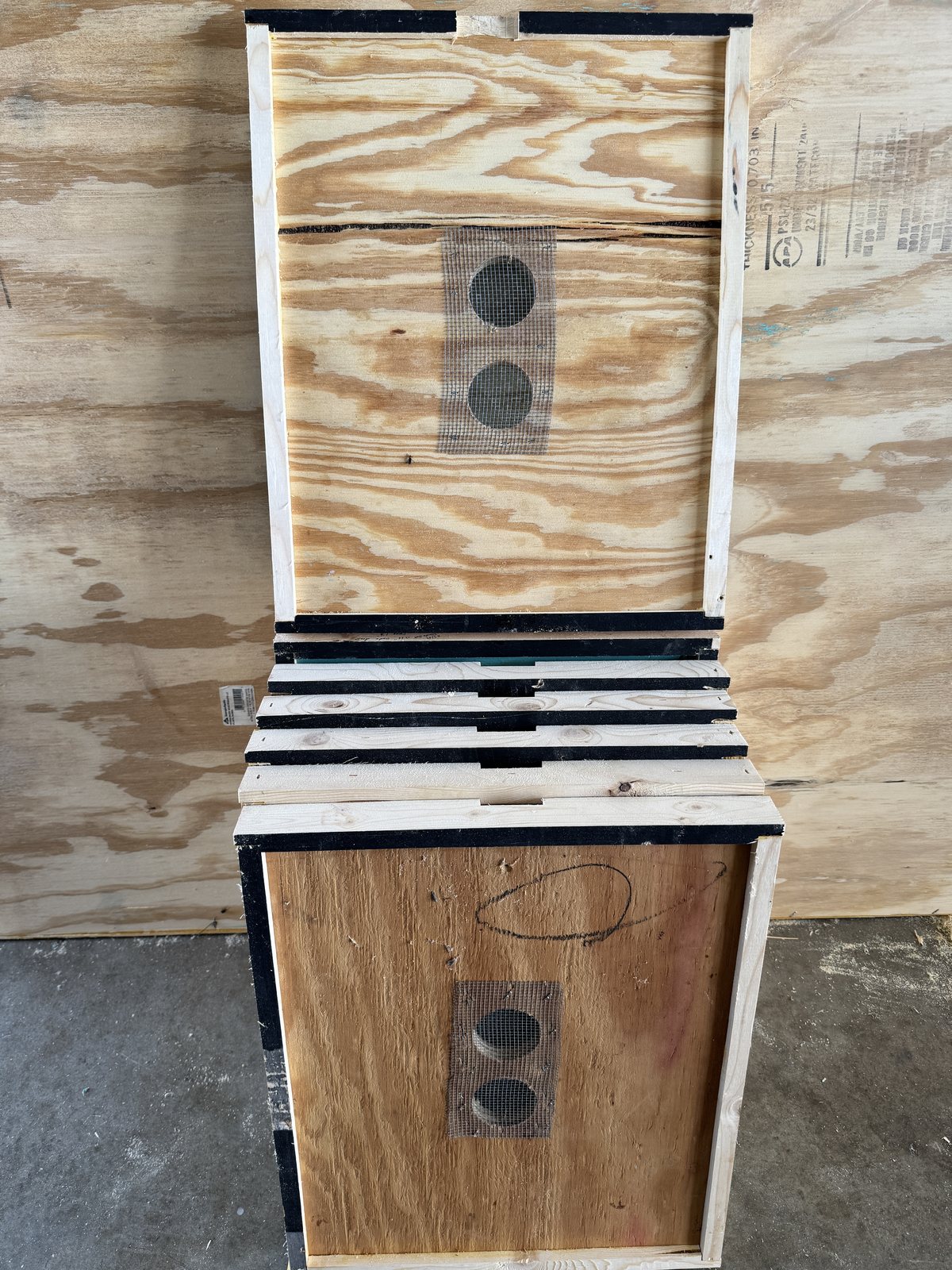 Stack of locally built 10-frame double screen boards showing paired screened openings