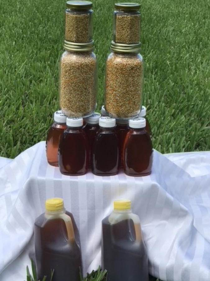 Honey bottles and jars of bee pollen displayed on a table